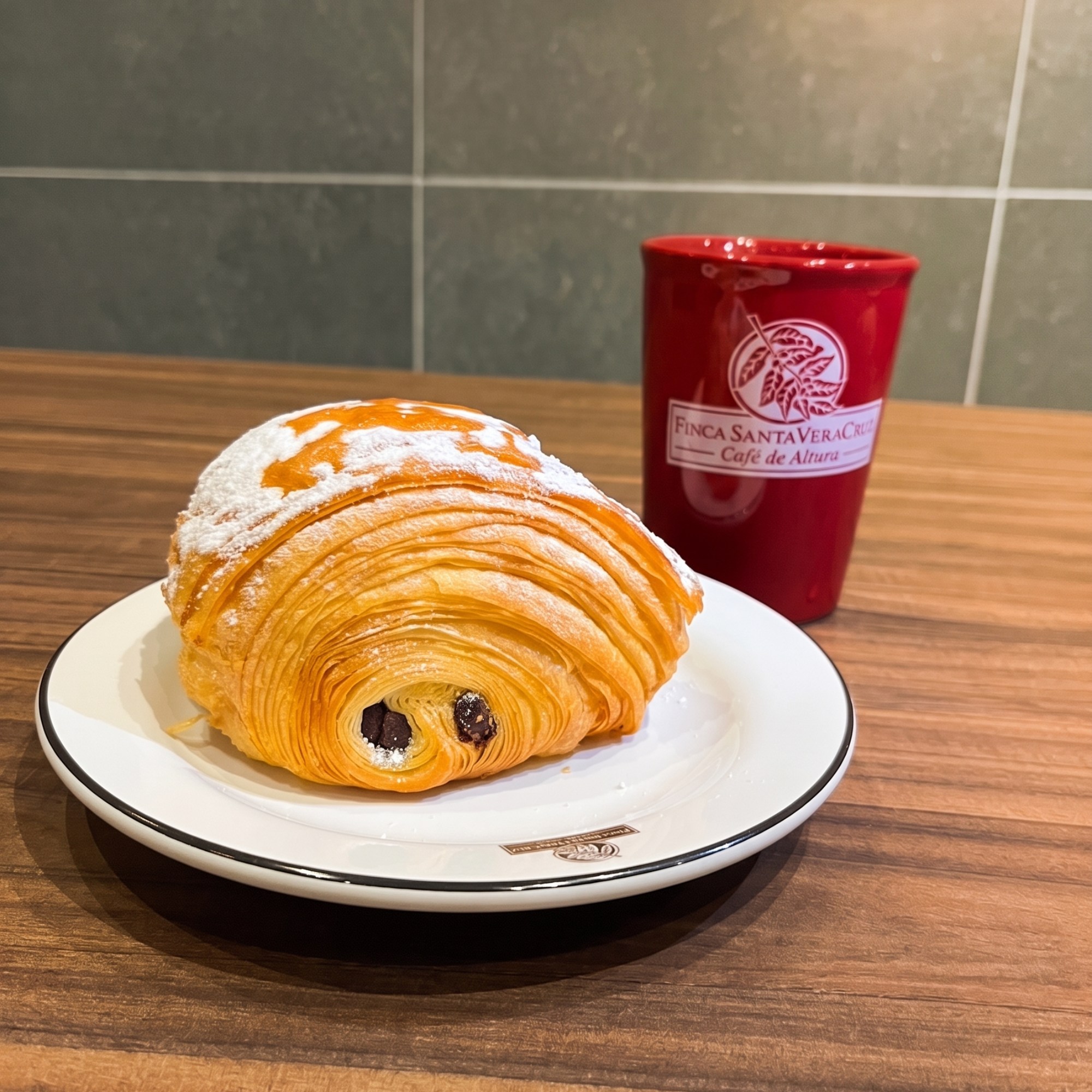 Croissant de chocolate con taza roja Finca Santa VeraCruz