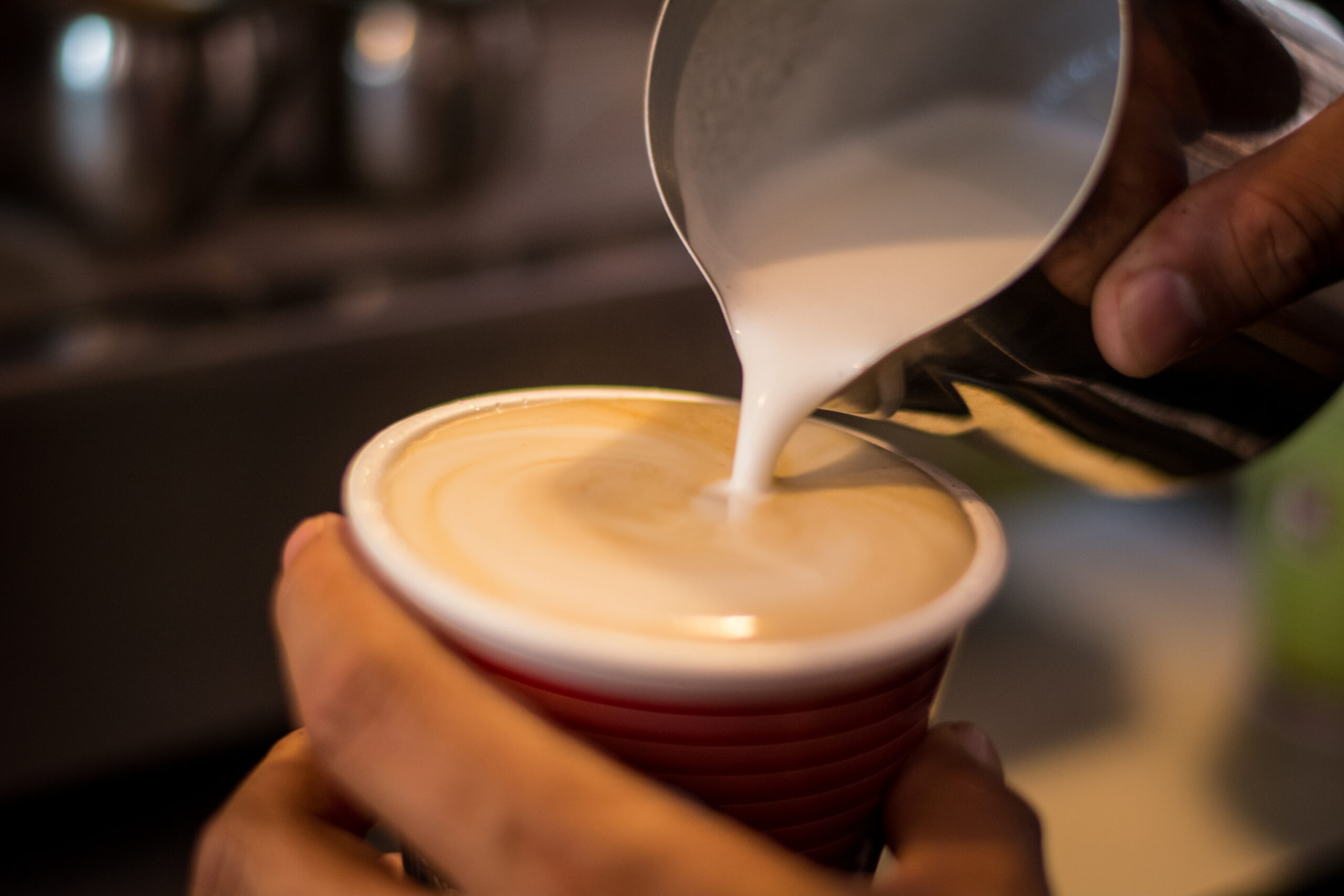 Barista vertiendo leche para crear arte latte